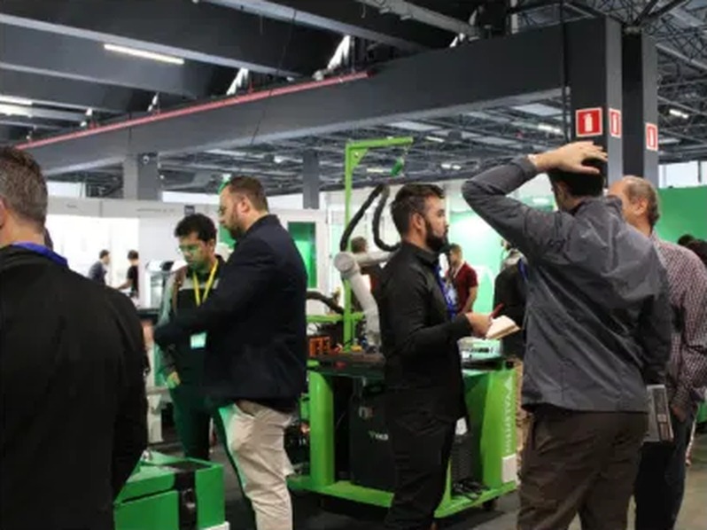 Visitantes acompanhando demonstração em estande