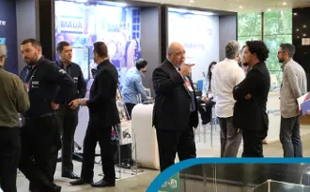Visitantes conversando em estande de expositor